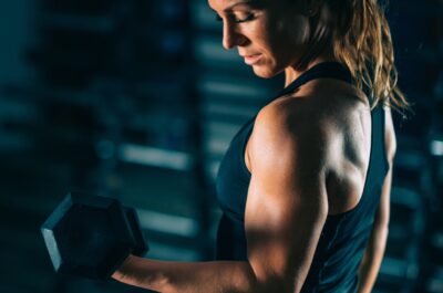 Cross training. Young woman exercising with dumbbells